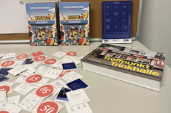 Mehrere Aufkleber, Broschüren und ein Bildband auf einem Tisch.