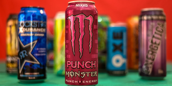 Verschiedene Energydrink-Dosen vor schwarzem Hintergrund