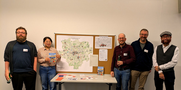 Vier Männer und eine Frau stehen neben einer Karte der Stadt Dortmund, auf der die Standorte der Kioske markiert sind.