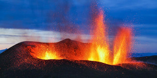 Ein Vulkan der glühende Magma ausspuckt.
